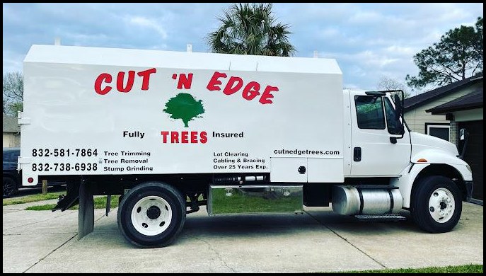 Cut 'N Edge Trees insured chip truck with logo, phone number and service list on the side